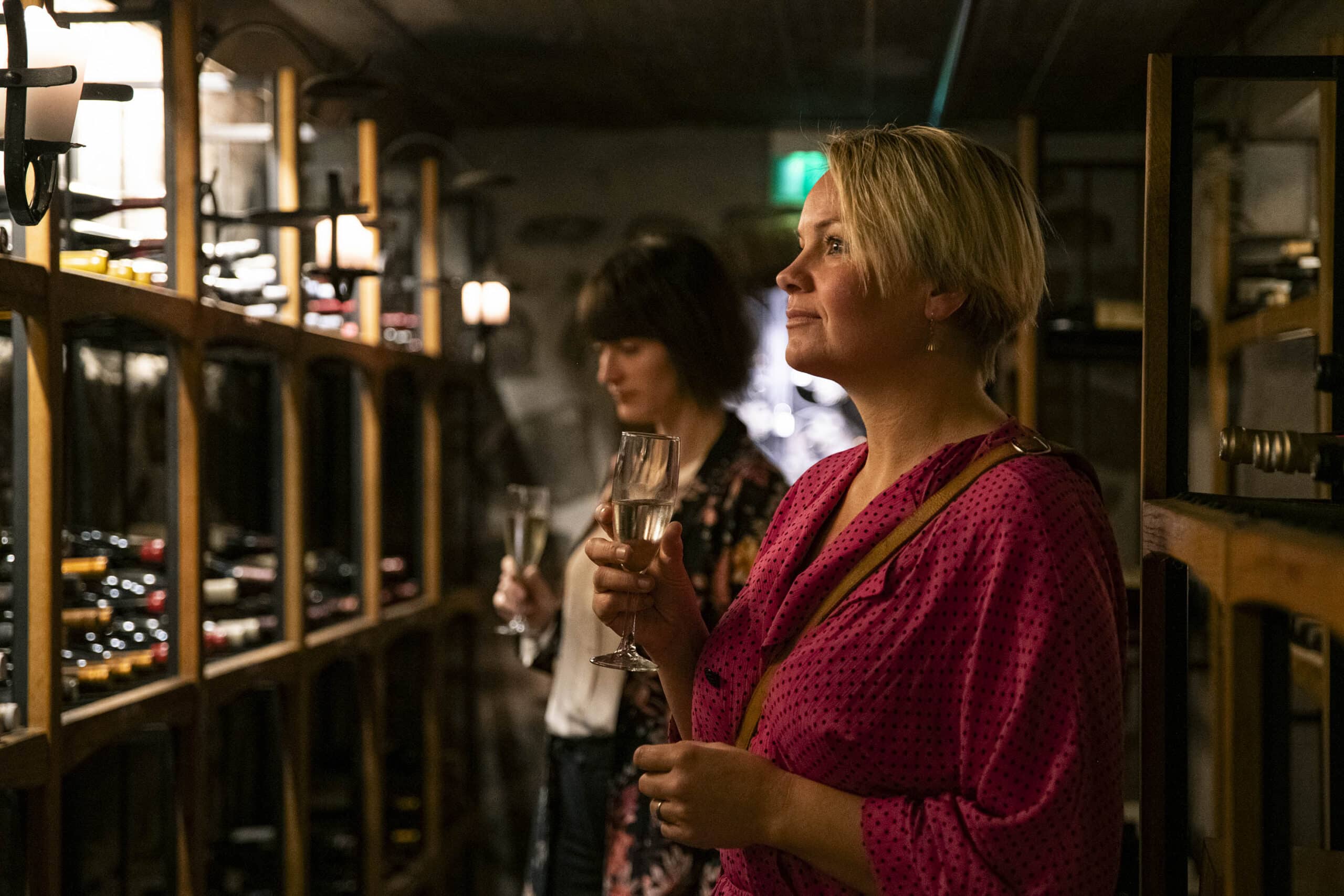 Kvinne ser på vinsamlingen i historisk vinkjeller på Refsnes Gods.