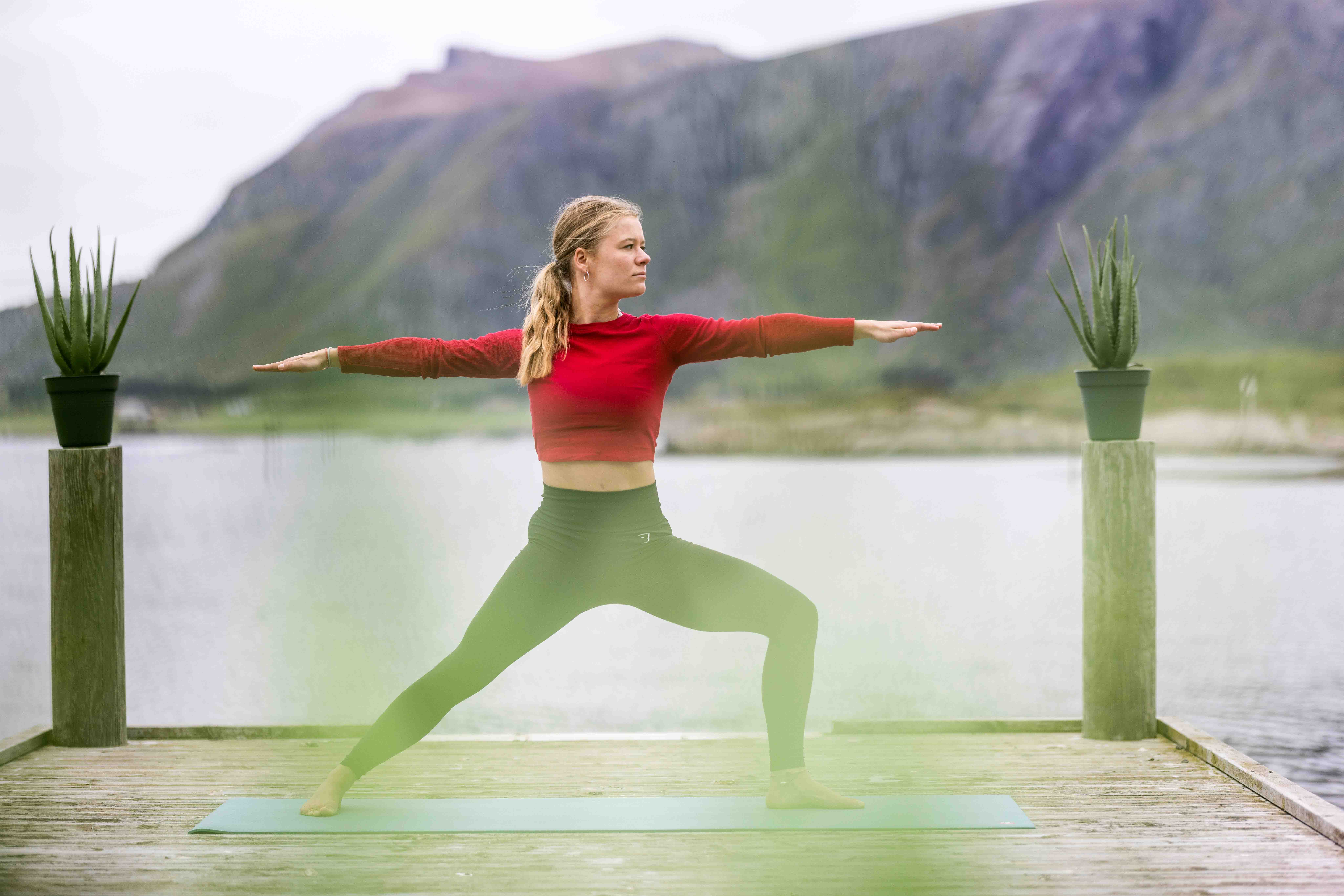 Person gjør yoga på kai ved havet i Hustadvika