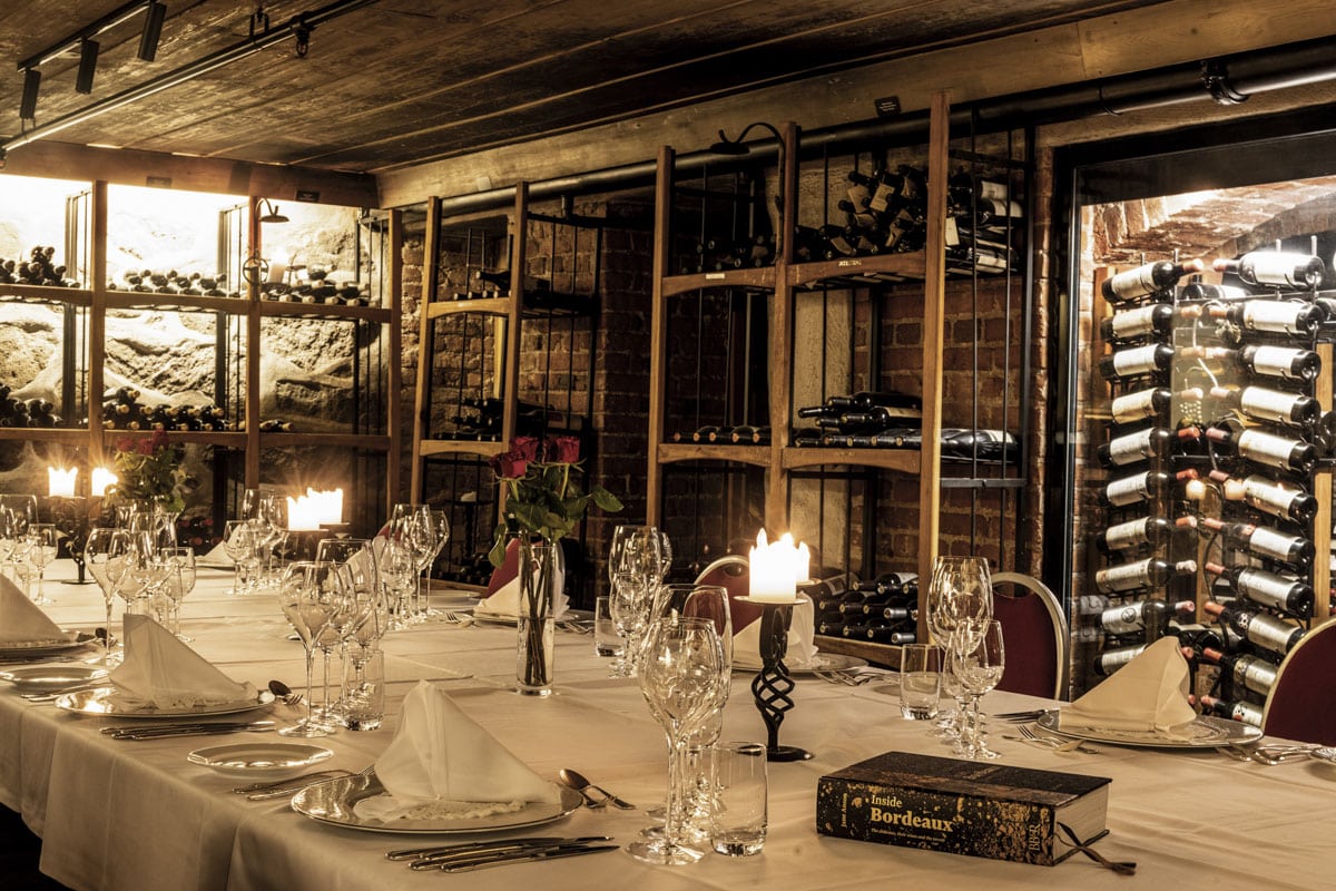 Festpyntet langbord i historisk vinkjeller på Hotell Refsnes Gods.